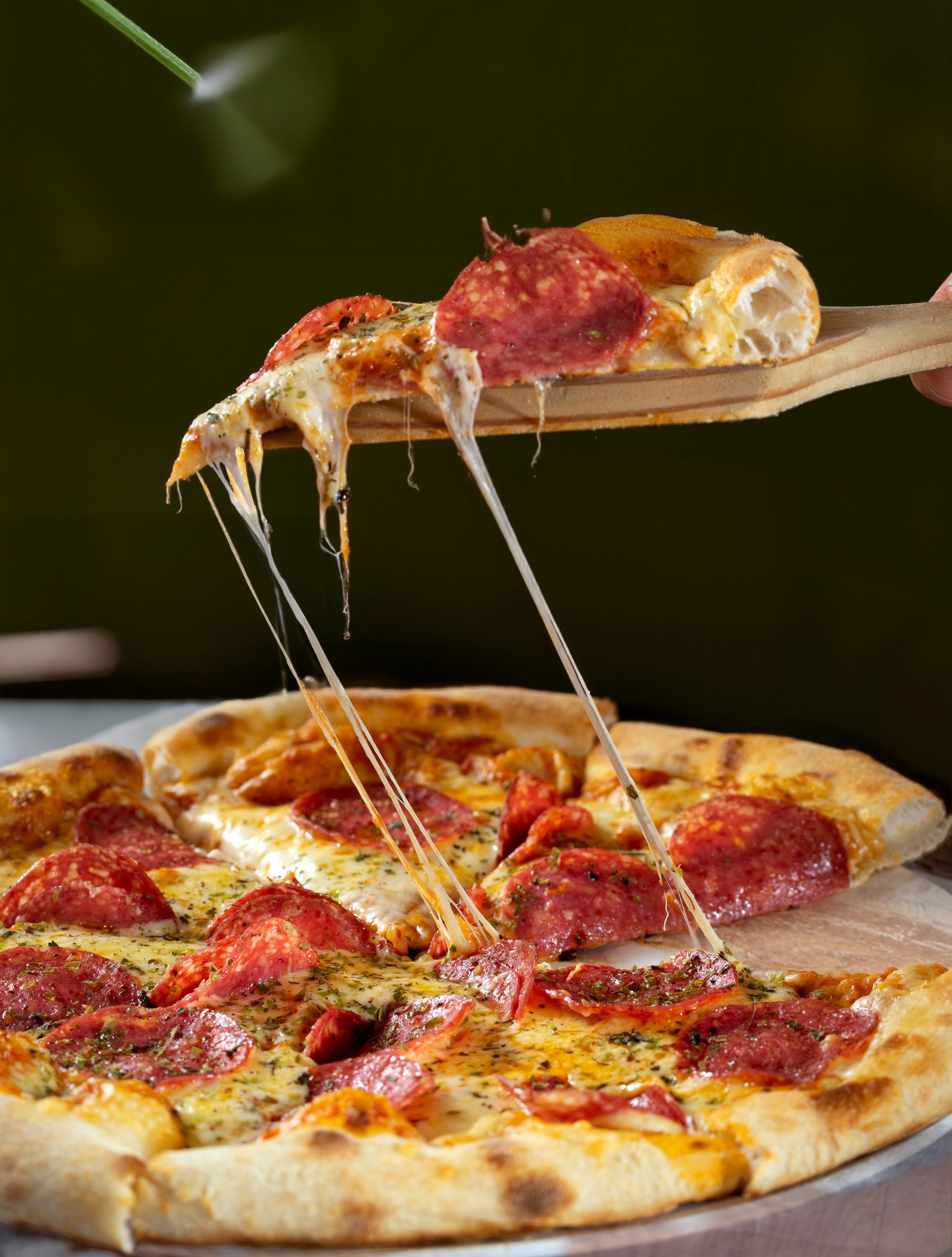 Porción de pizza levantada con queso estirándose, Andiamo